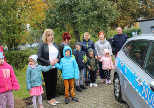 Hana, Maja, Miłosz, Adaś, Olek i Ania z wychowawcami przed radiowozem policyjnym